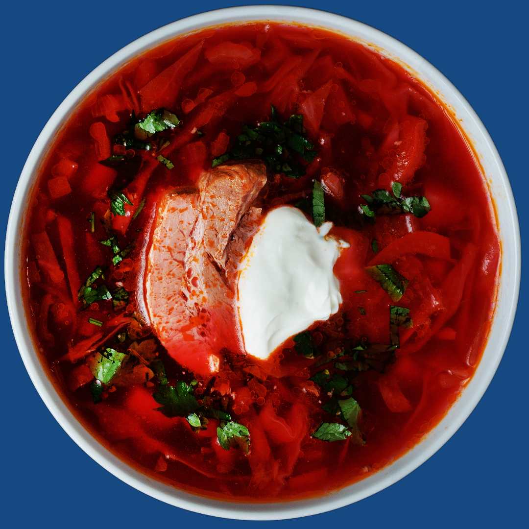 Bowl of Ukrainian borshch with sour cream and fresh herbs